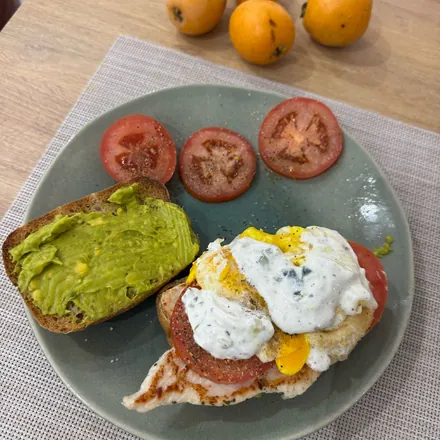 Tostada de aguacate y tostada de tomate con huevo, en un plato verde